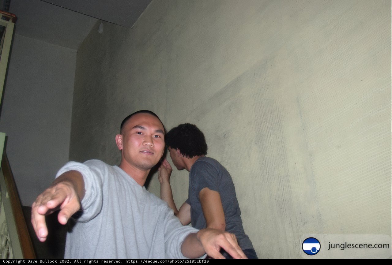 Two Men Posing in Front of Wall