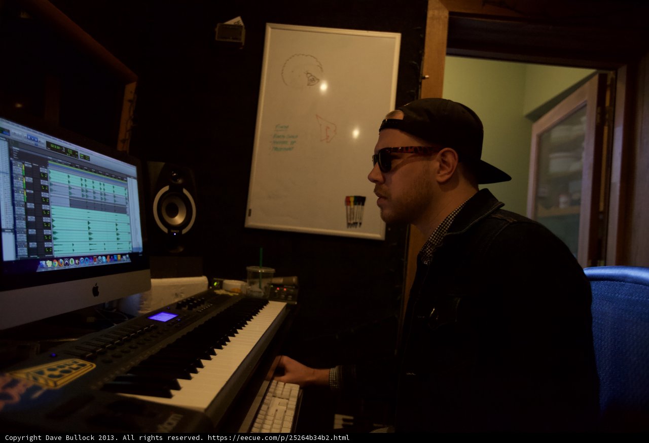 Hat-wearing Musician Working on Computer