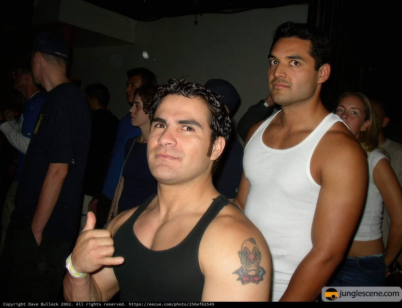 Tattooed Men In Tank Tops Pose With Friend