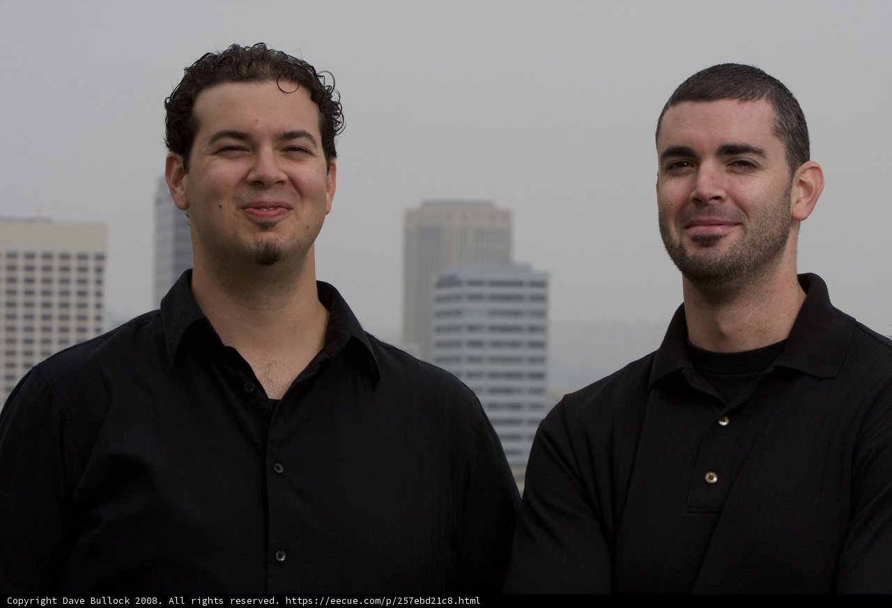 Smiling Duo in front of a Skyscraper