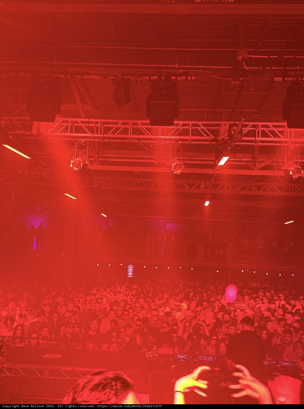 Red-Lit Concert Crowd Under Stage Lighting Rig