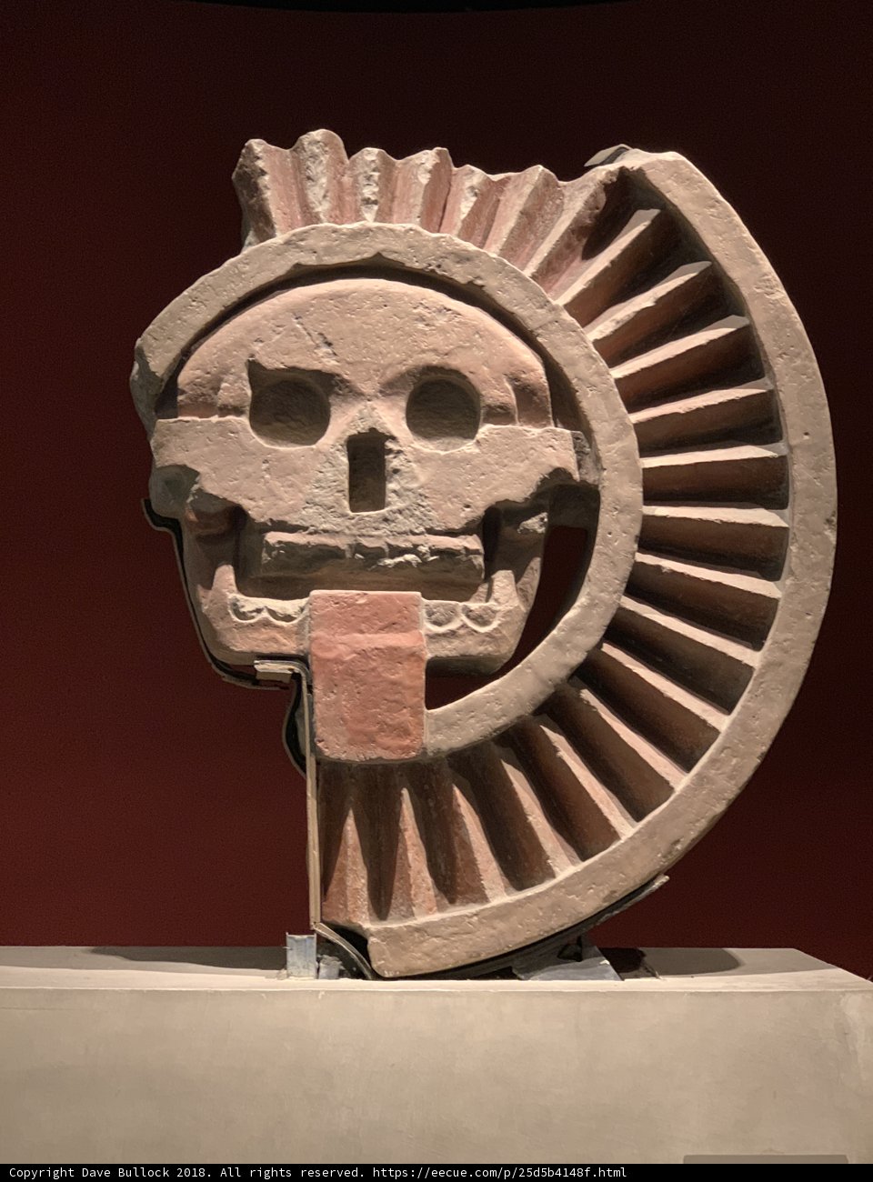 Ancient Stone Sculpture of a Head with Symbolic Wheel Emblem