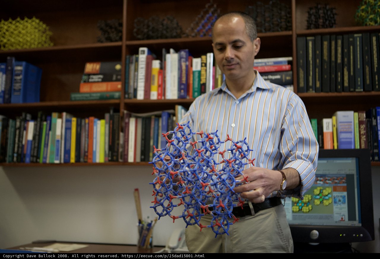 Omar M. Yaghi showcases model of molecule in front of impressive bookshelf
