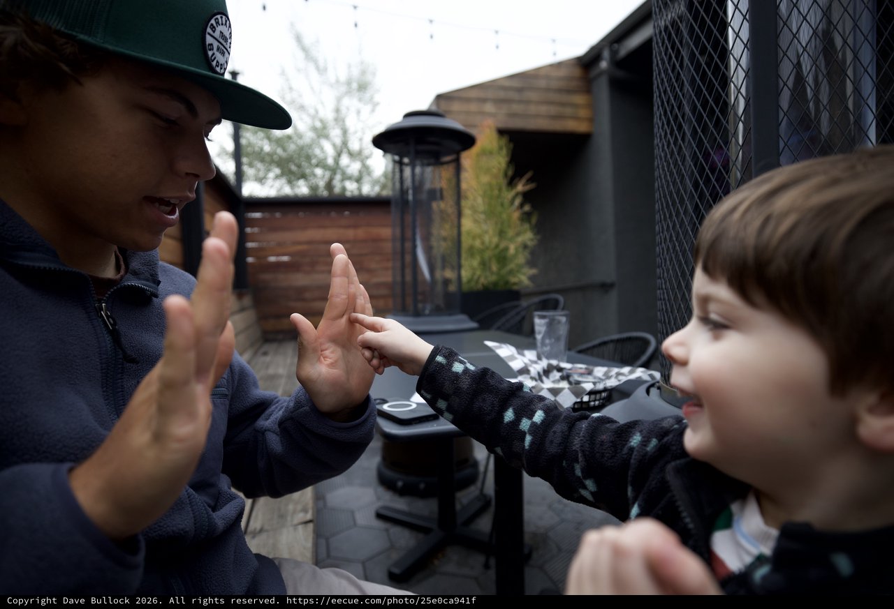 Joyful High Five Between Adult and Children Outdoors