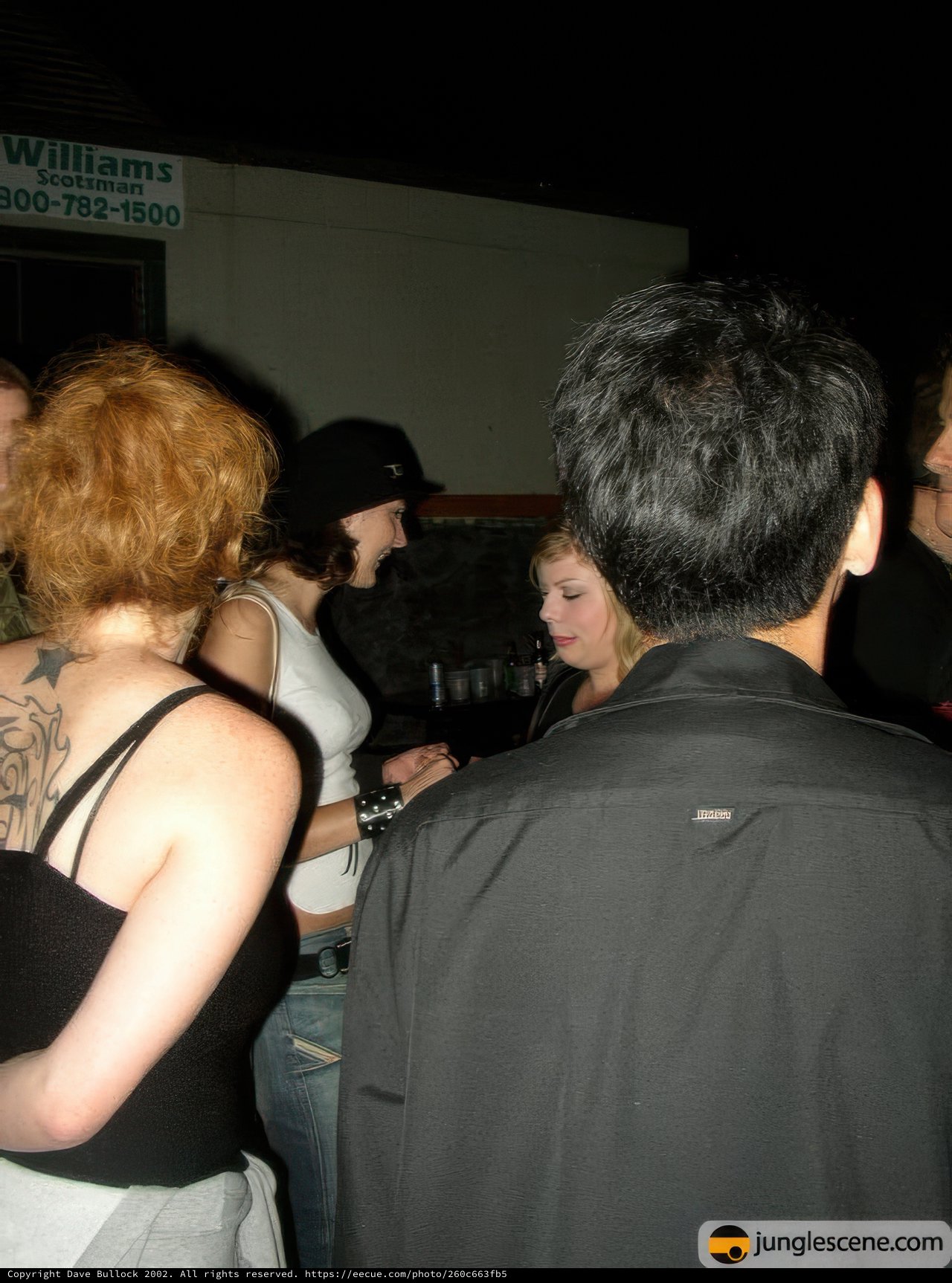 Tattooed Man in Club with Friends