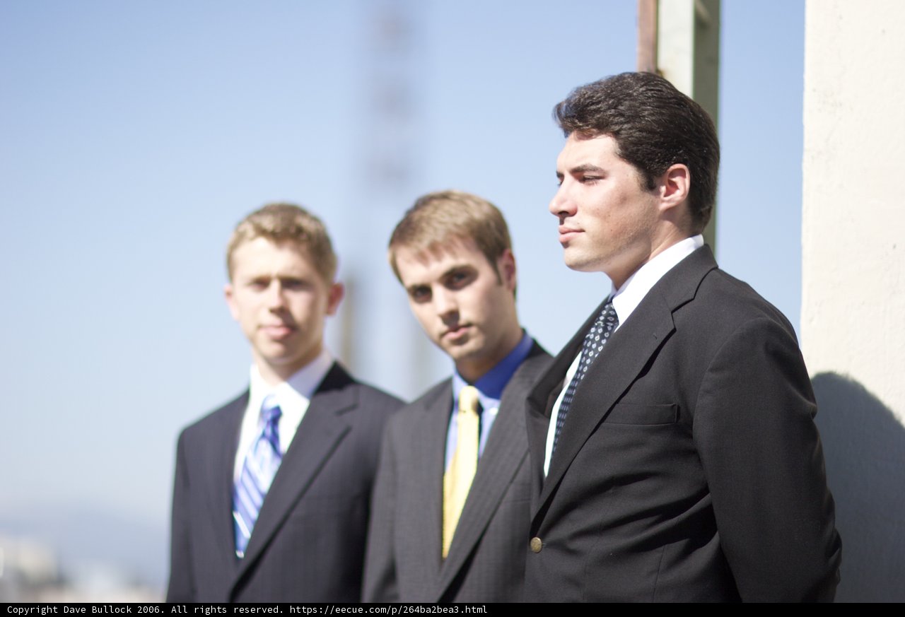 Three Men in Suits with Blue Sky Background