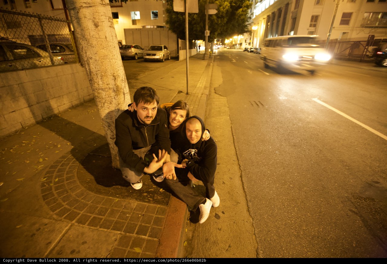 Three Friends Celebrating on City Sidewalk at Night