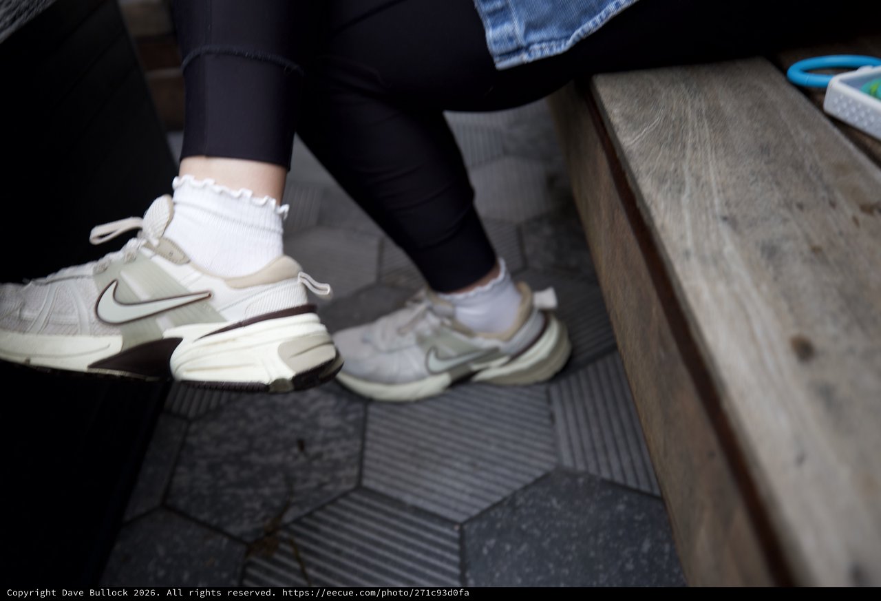 White Nike Sneakers with Ruffled Socks on Hexagonal Tile Floor