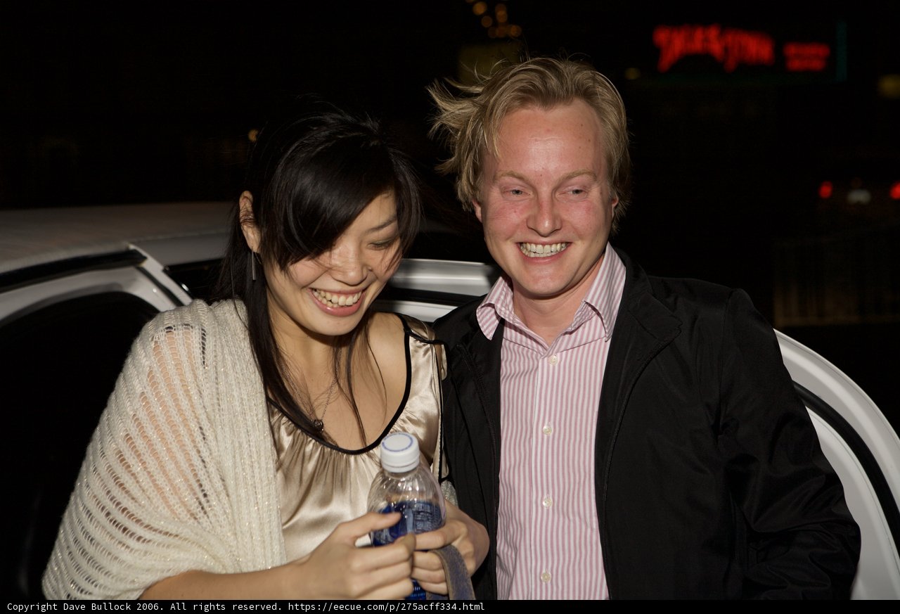 A Joyous Couple Posing Next to their Car