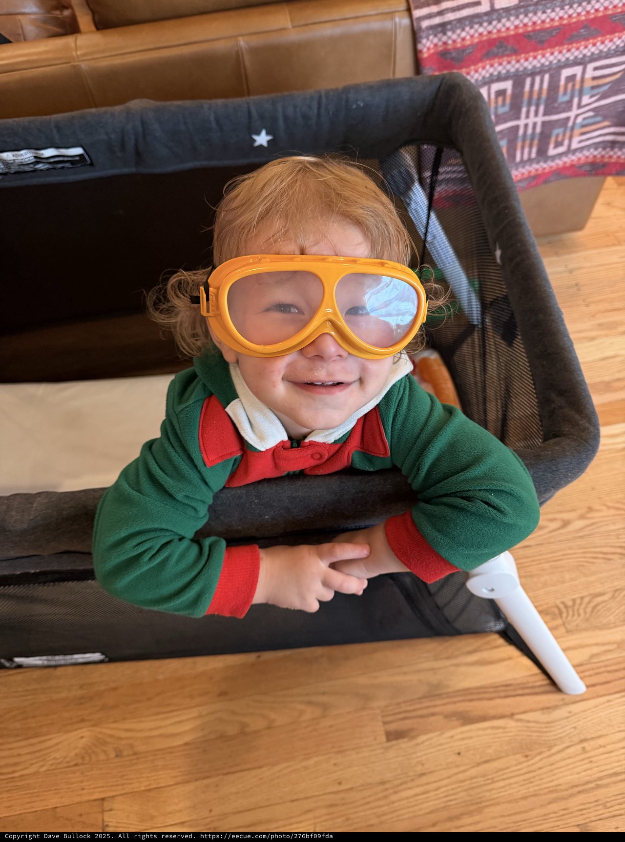 Cheerful Child in Orange Goggles and Green Jacket