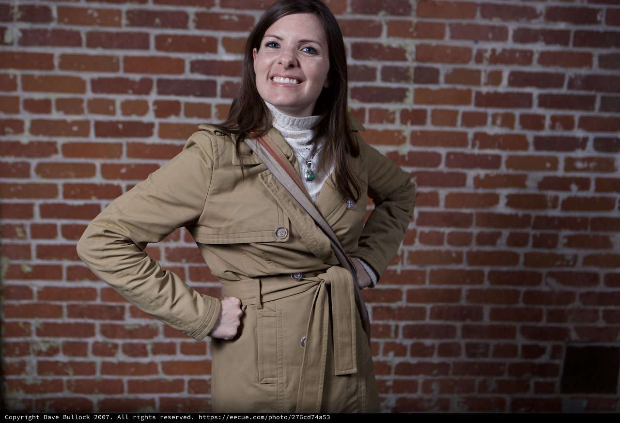 Confident Woman Posing Against Urban Brick Wall