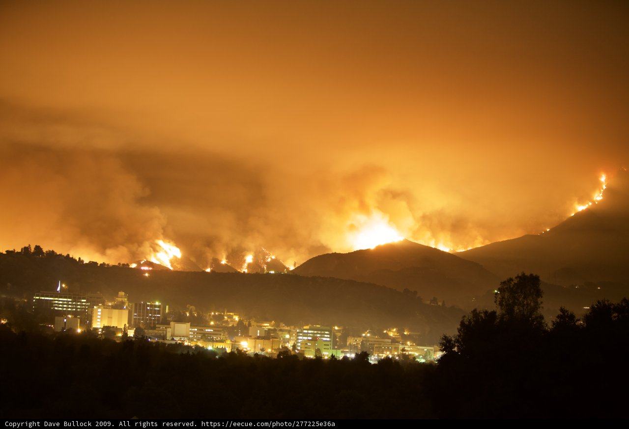 Flames Engulf the Hills Above a City