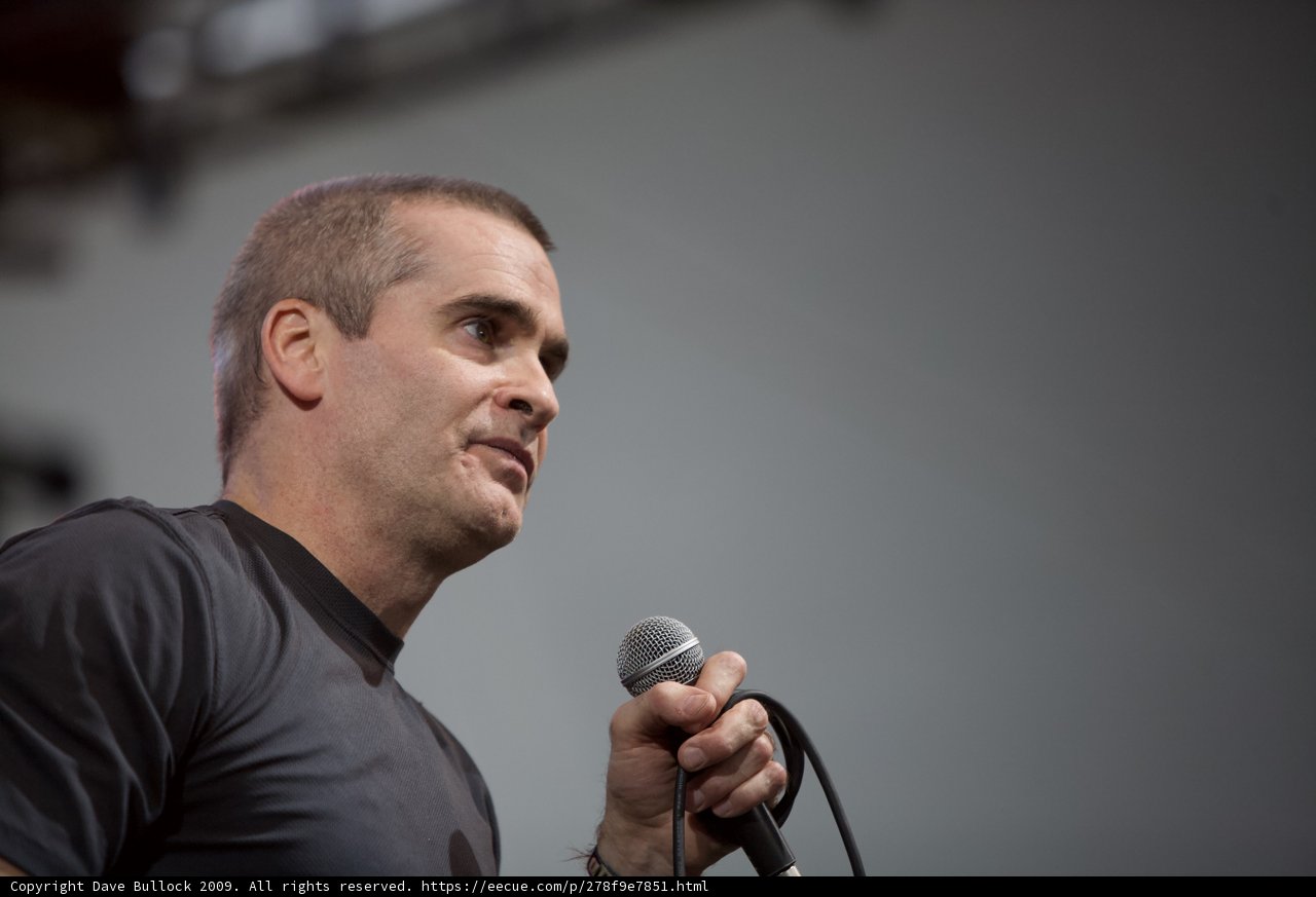 Henry Rollins Takes the Stage with Microphone in Hand