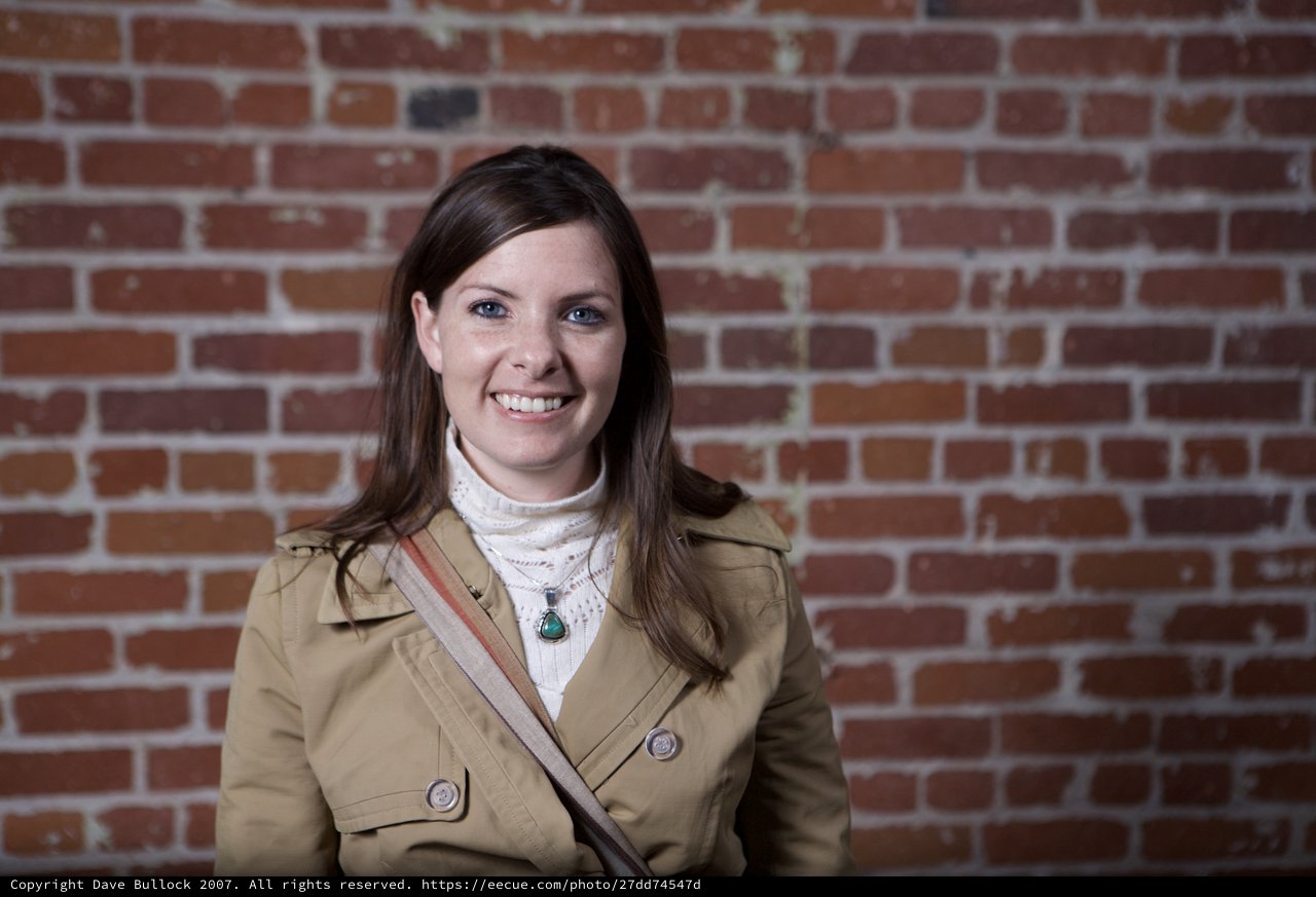 Smiling Woman Portrait Against Rustic Brick Wall