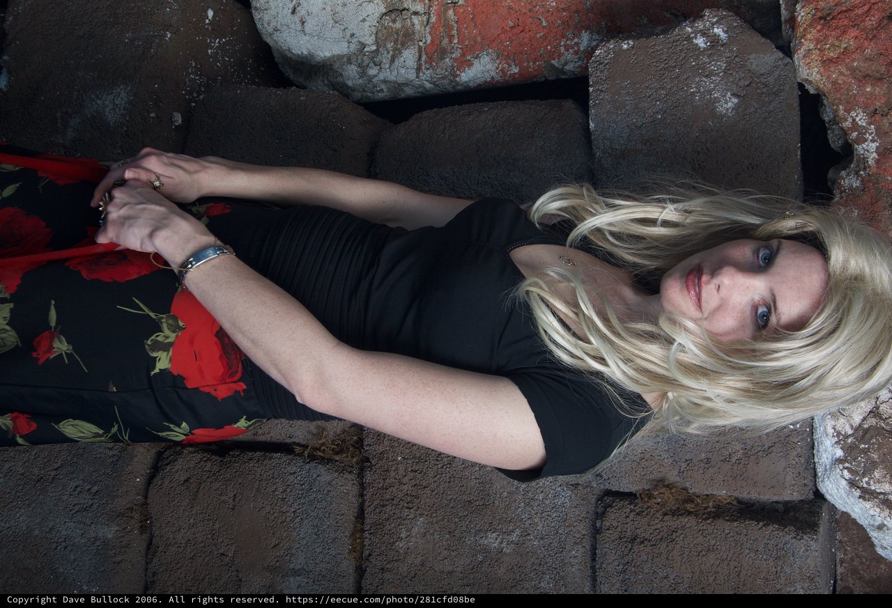 Blonde Woman Poses Against Rustic Stone Wall