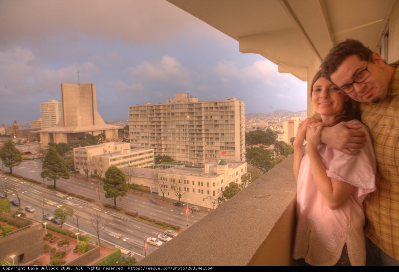 New Parents Embrace on Hotel Balcony Overlooking San Francisco