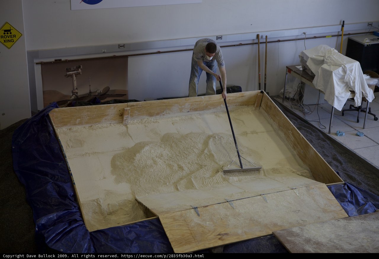 Man Cleaning Sand Box in Plywood Room