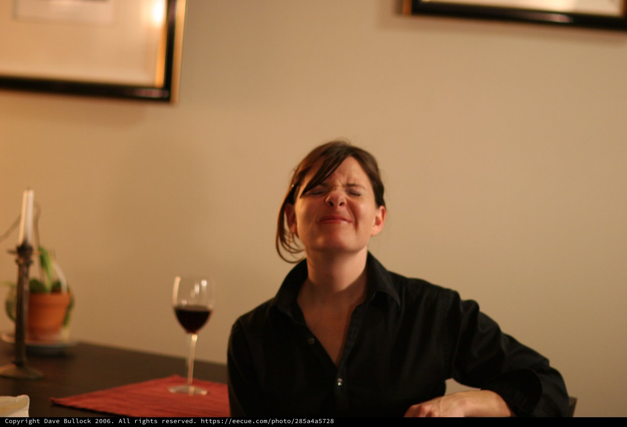 Woman Savoring Red Wine at Restaurant Table