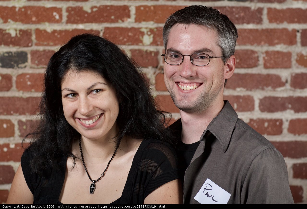 Smiling Couple Poses in Front of Textured Brick Wall