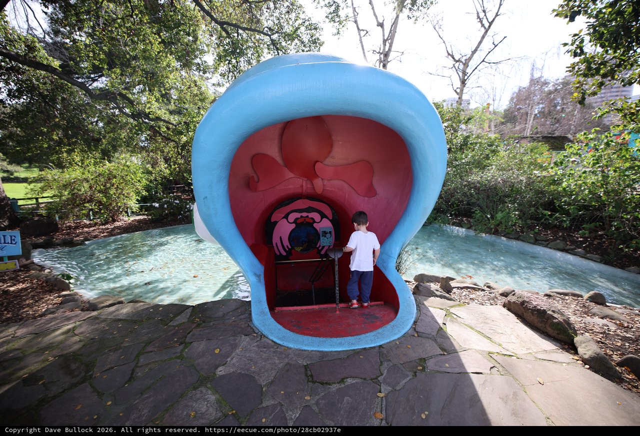 Child Exploring Giant Mouth Sculpture at Fantasyland