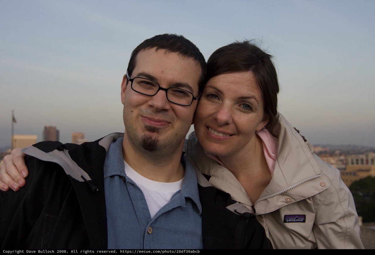 Couple Smiling Together on City Rooftop at Dusk