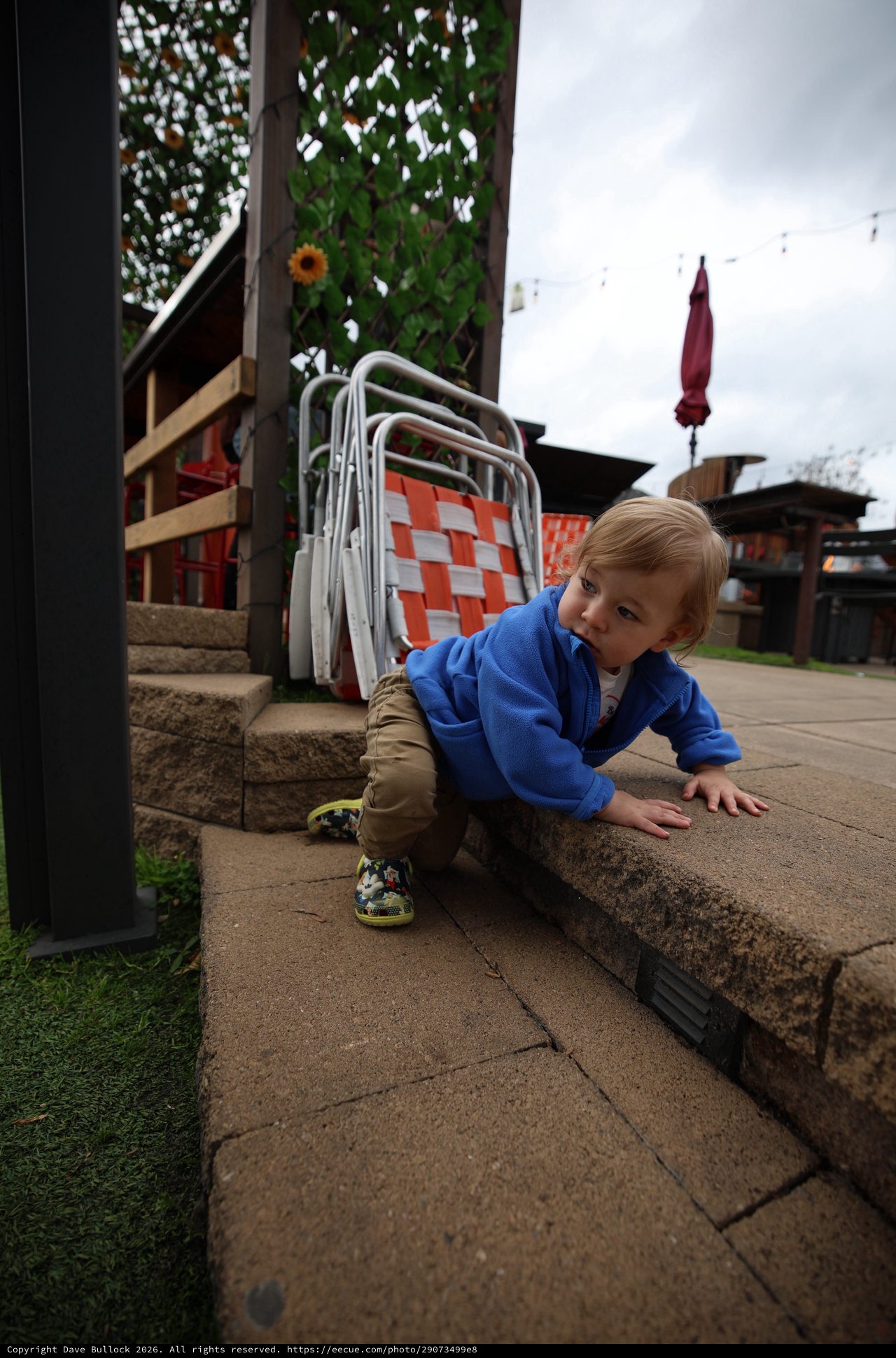 Toddler Exploring Outdoor Patio Steps on Cloudy Day