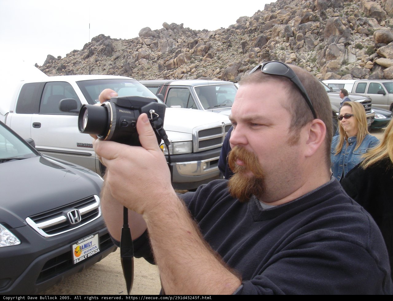 Photographer on a Hill Captures SUVs in a Parking Lot