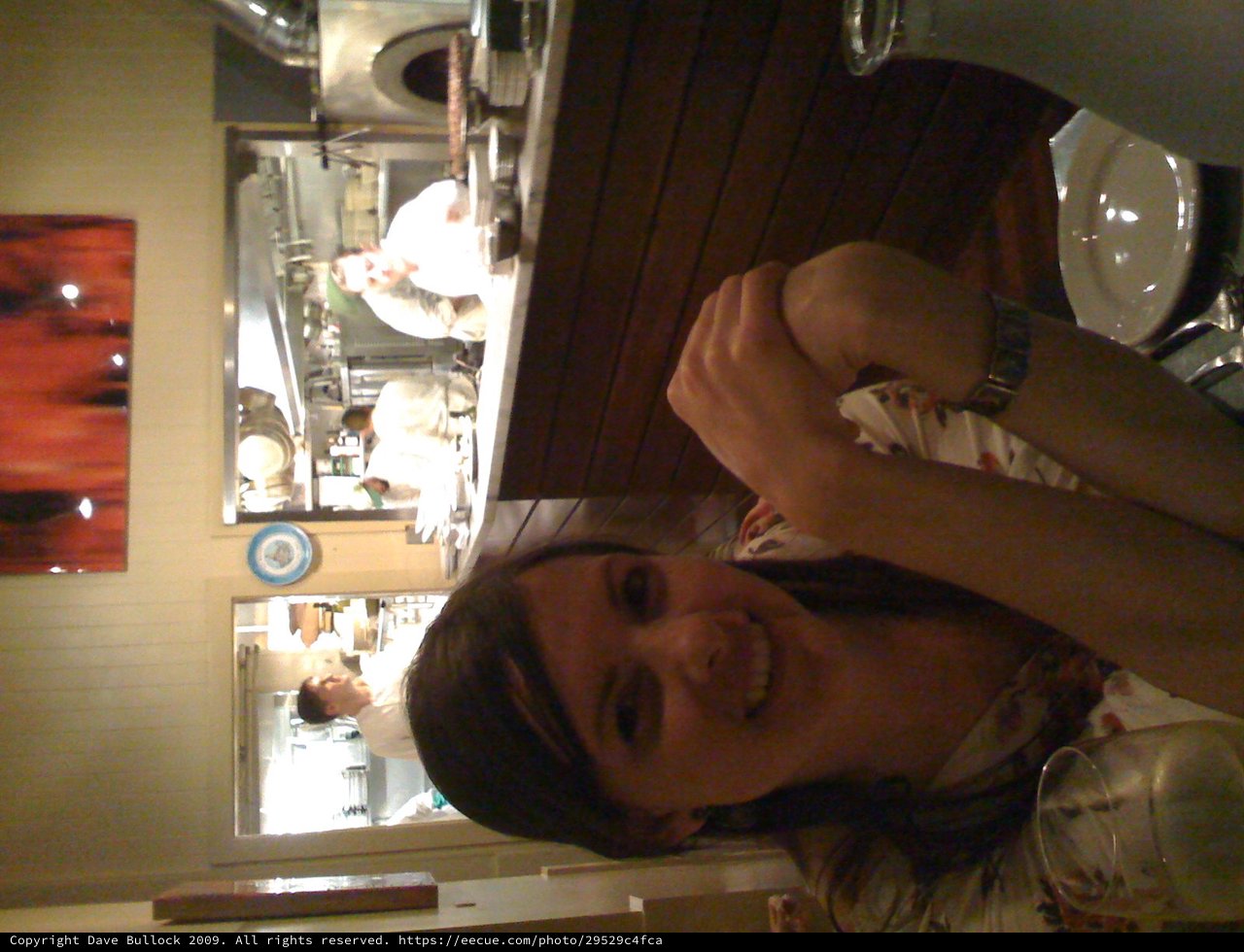Woman Smiling at Open Kitchen Restaurant Table