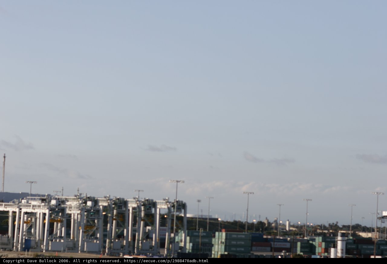 Massive cargo ship docks at busy waterfront