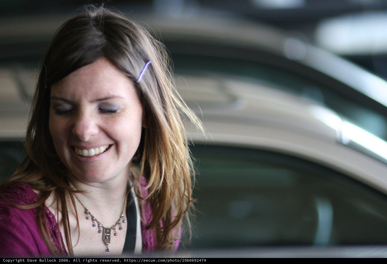 Joyful Woman Smiling Near a Car Door