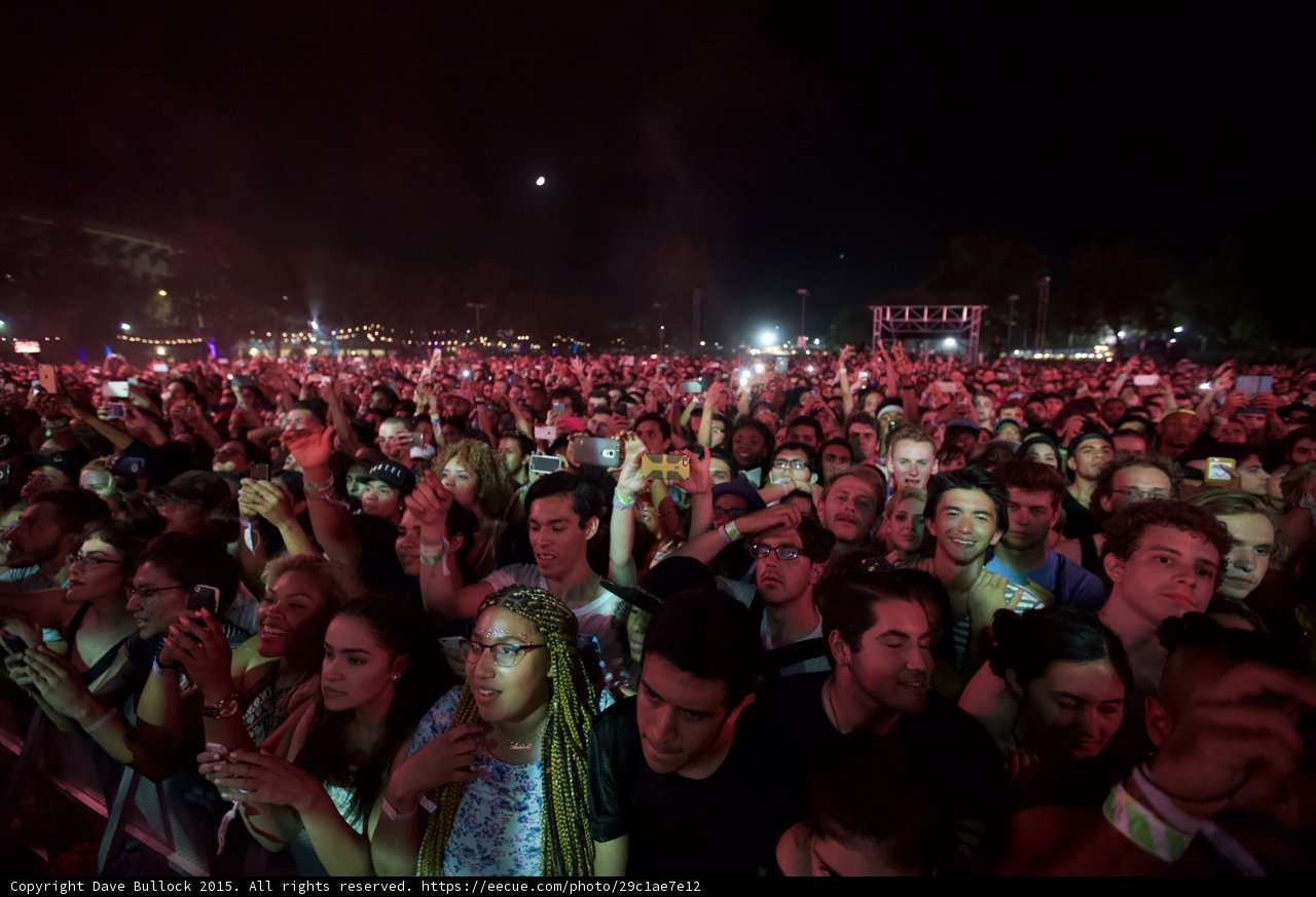 FYF Fest Wide Crowd Woman Green Braids Glasses Floral Shirt Moon Phones Yellow Case Stage Scaffolding
