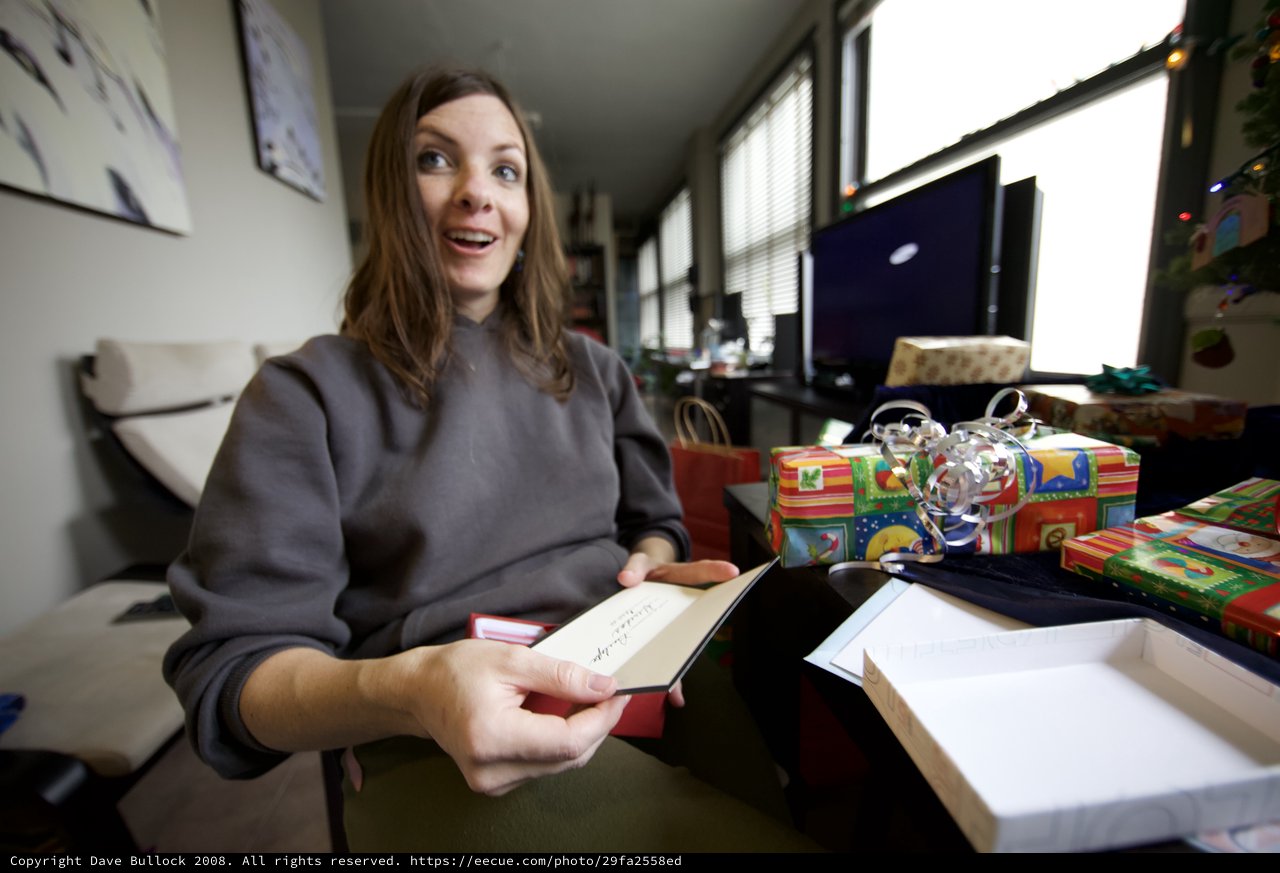 Joyful Woman Opens Christmas Card With Surprise