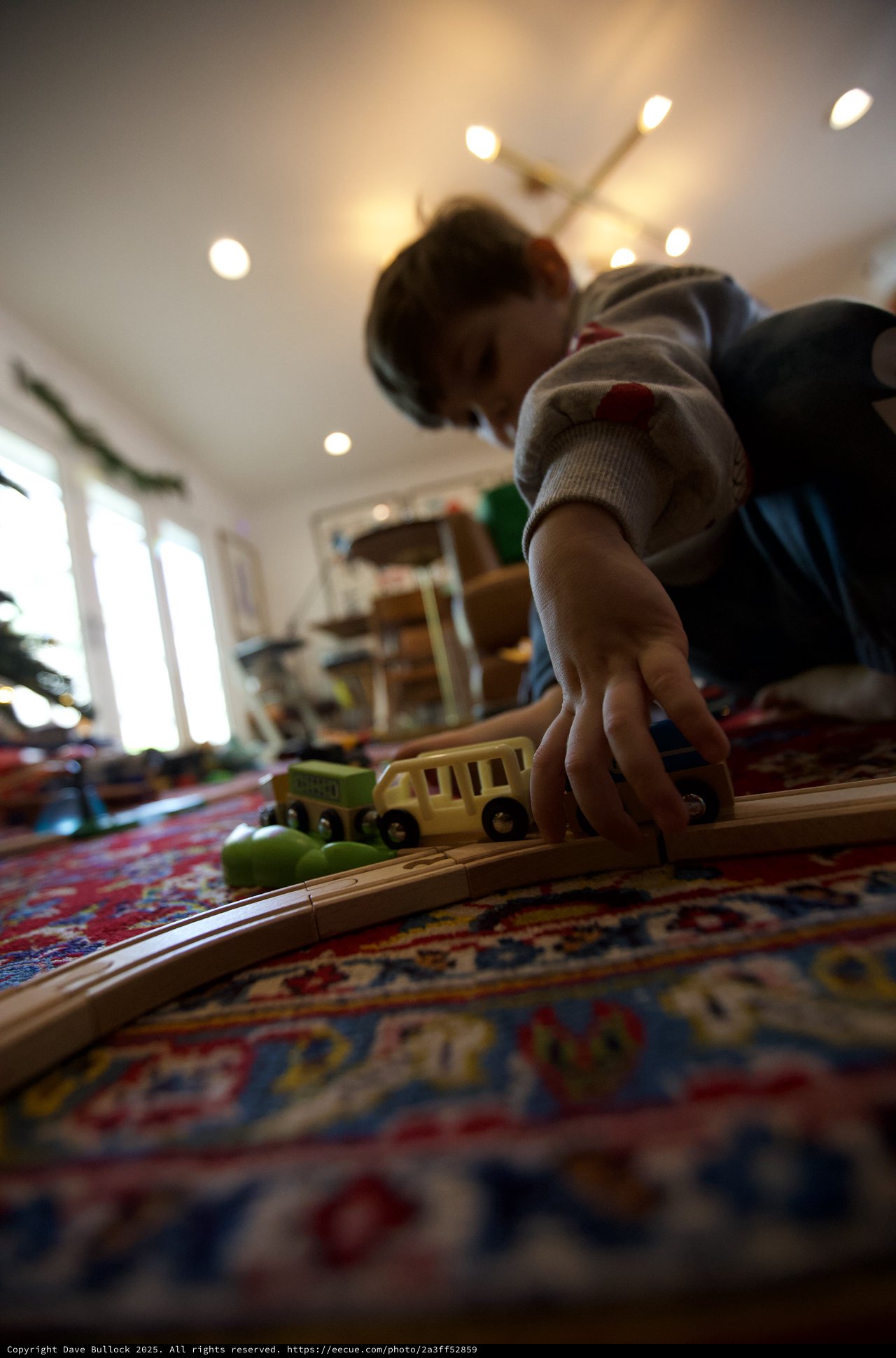 Child Playing with Wooden Train Set at Home