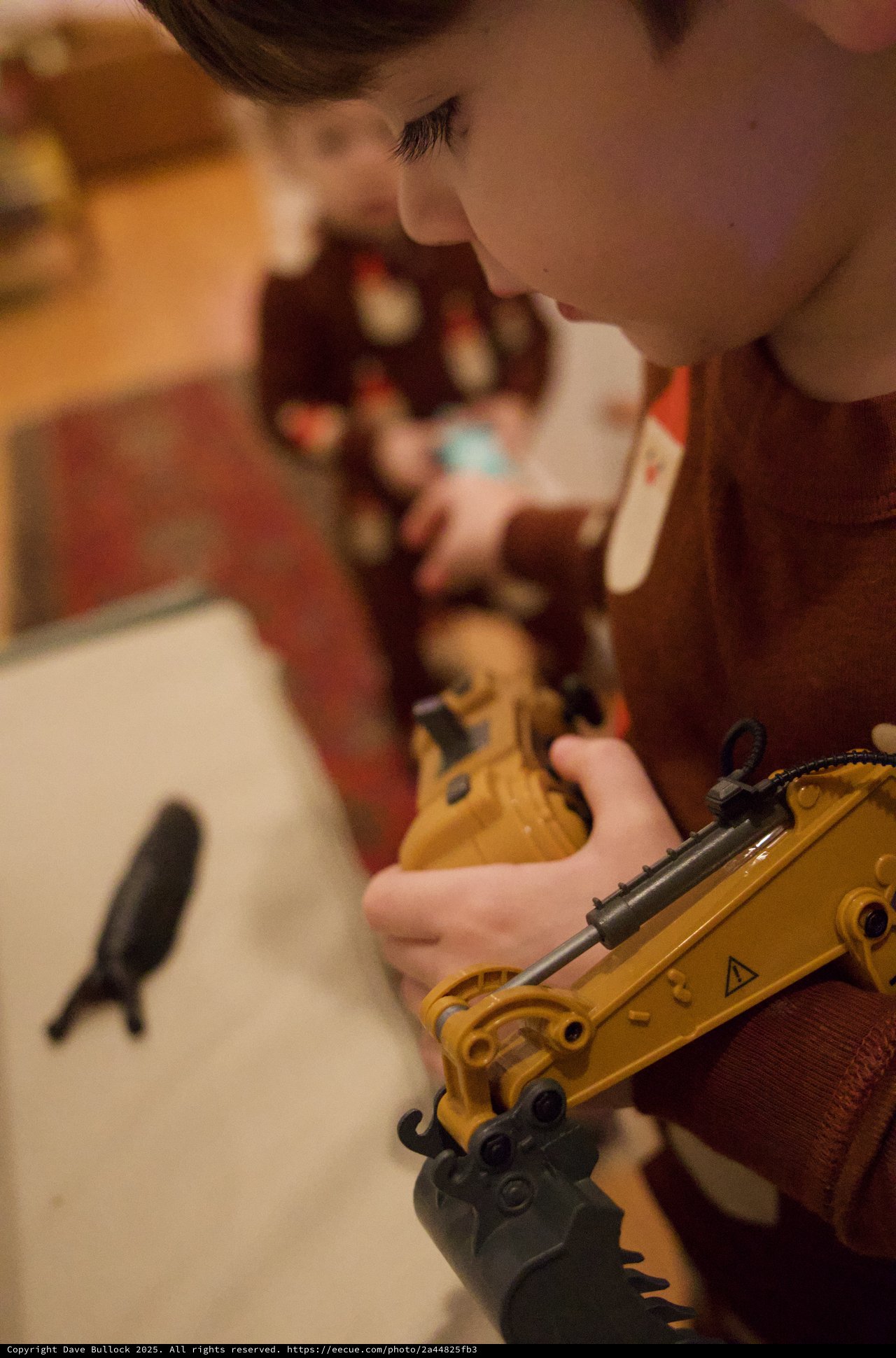Child Playing with Yellow Construction Toy Crane at Christmas