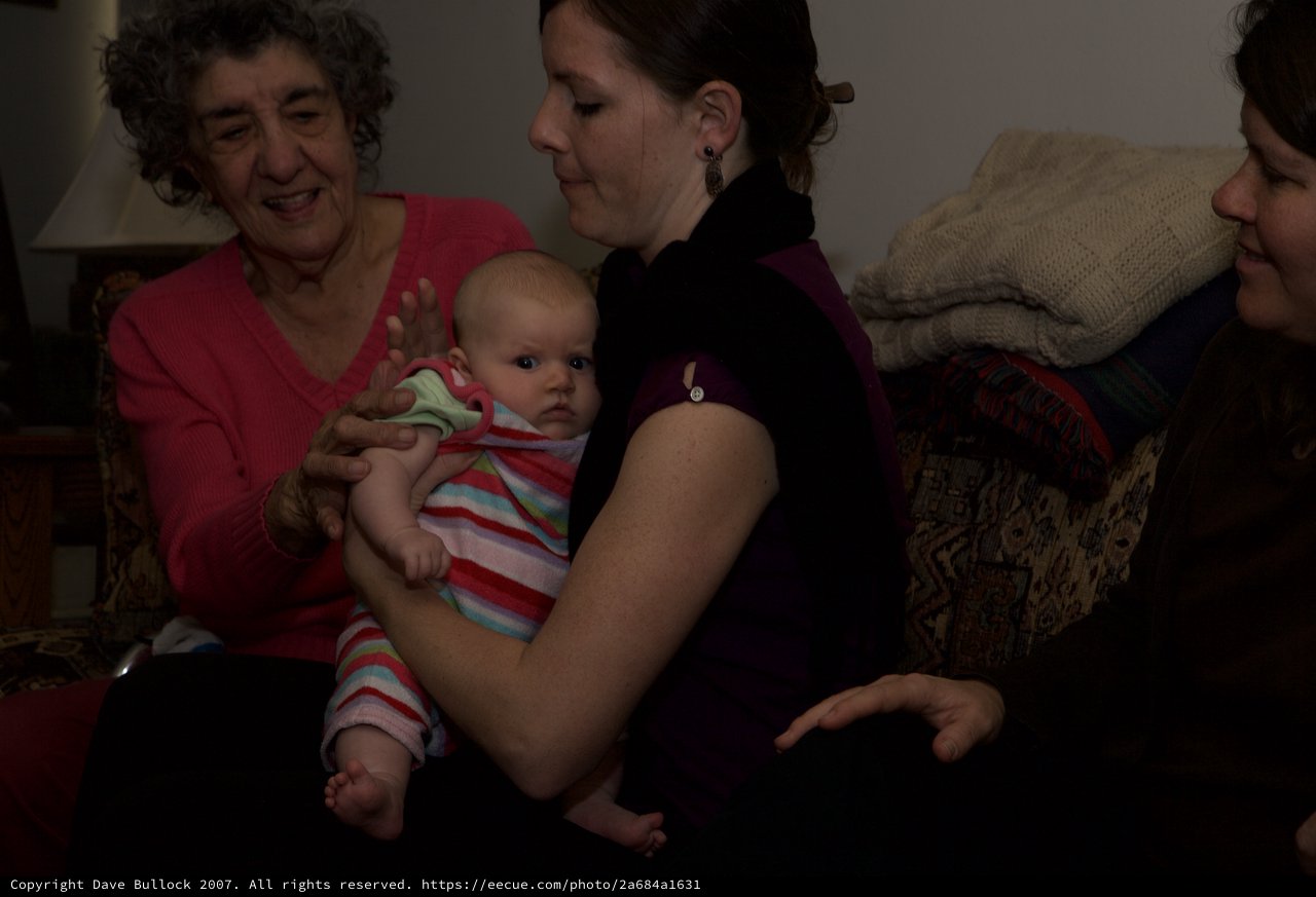 Three Generations Share a Tender Moment with Newborn