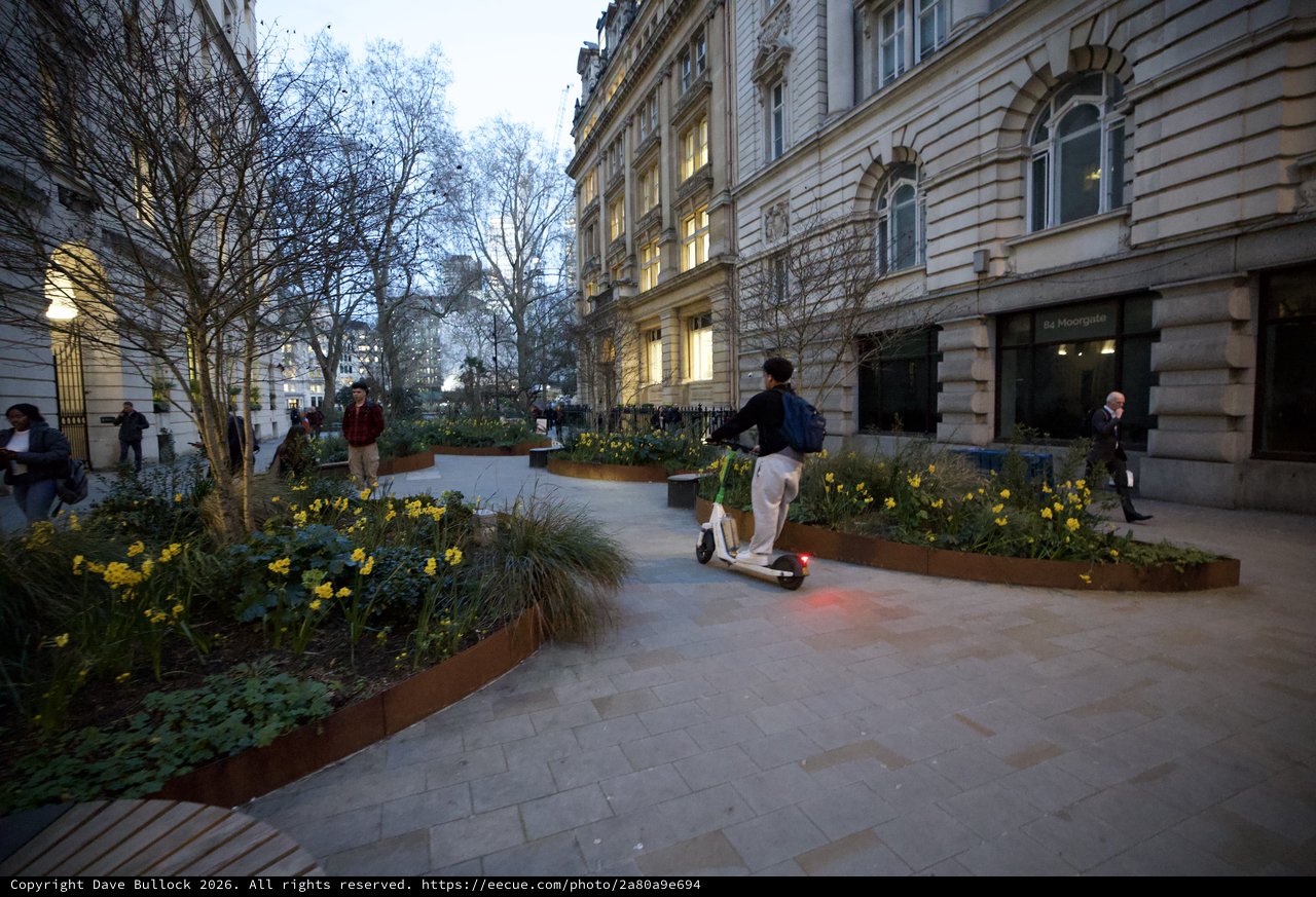 Electric Scooter Rider in London Garden Square at Dusk