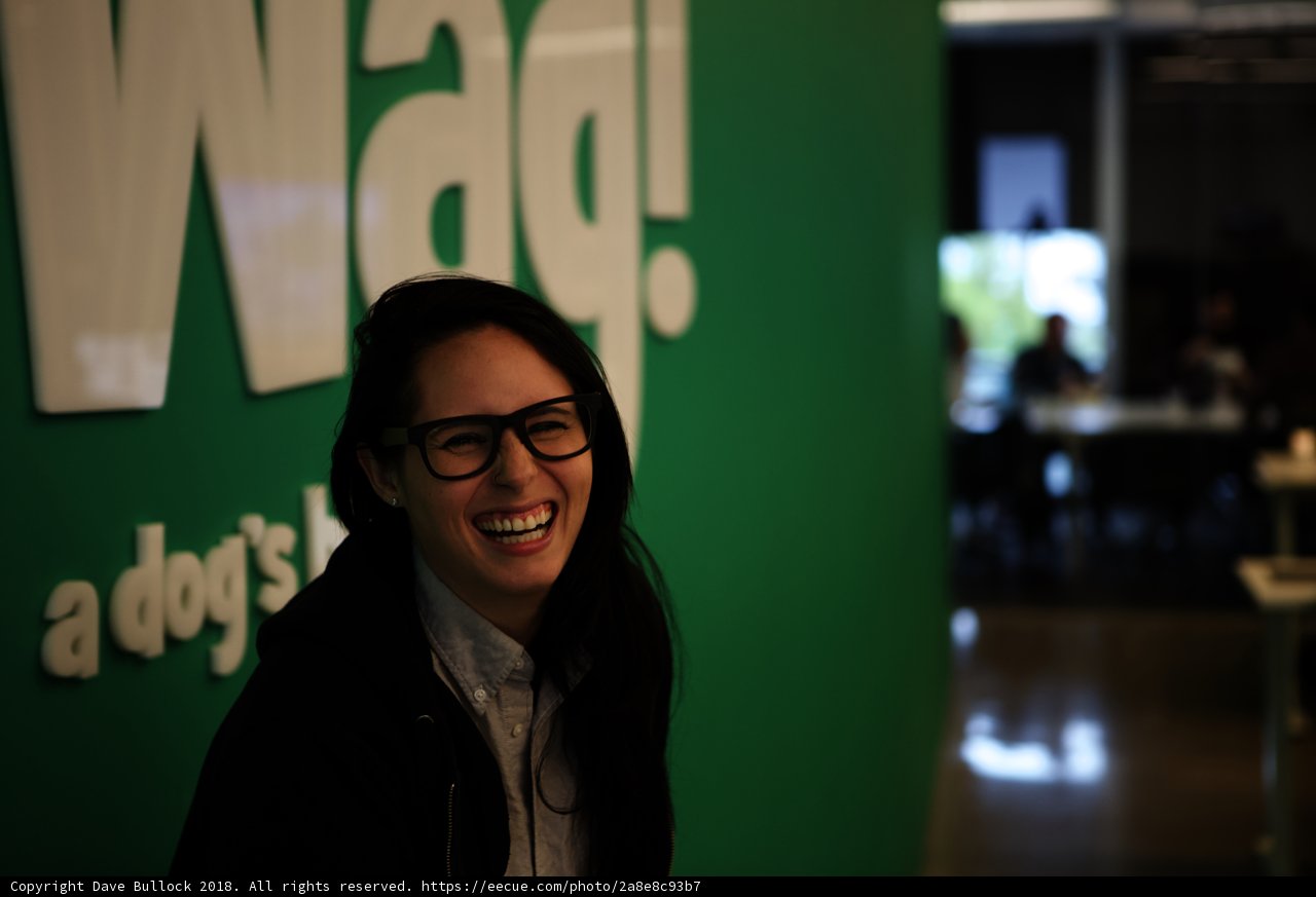Woman Smiling with WAG Logo in the Background