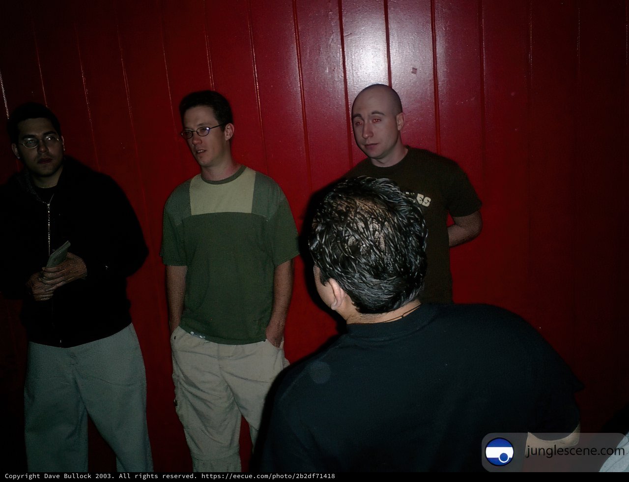 Group of Four Men in a Red Wall Background