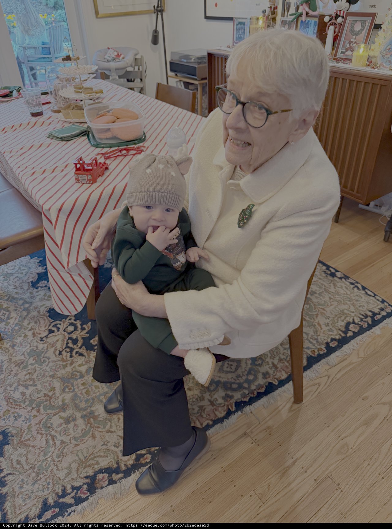Grandmother Lovingly Holds Baby Grandchild at Home