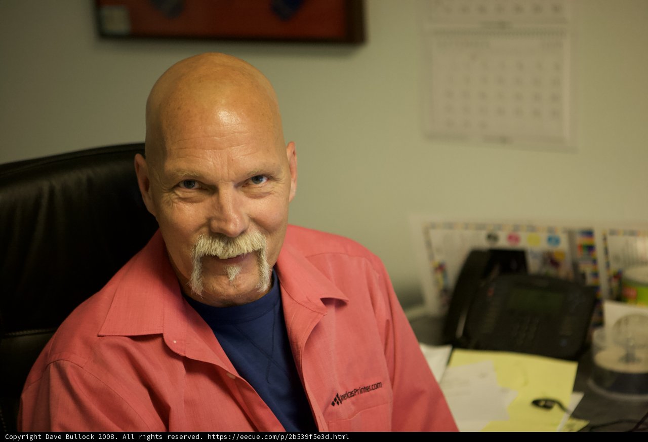 Bald Man in a Coat Sitting in an Office