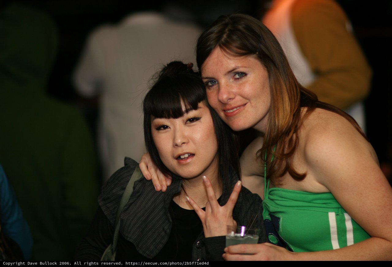 Two Friends Pose Together at a Nightclub Event