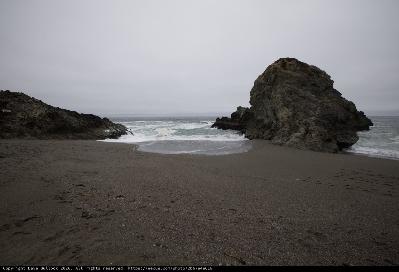 Rugged Cove Where Waves Meet Dark Sand