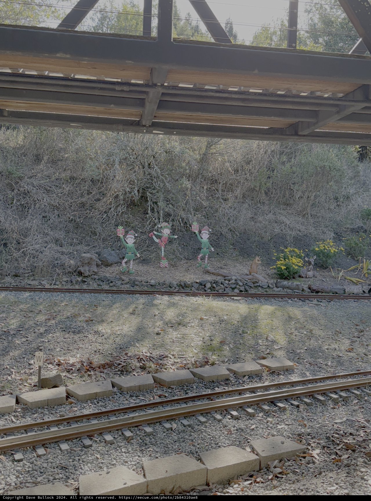 Whimsical Elf Figures Under Railway Bridge