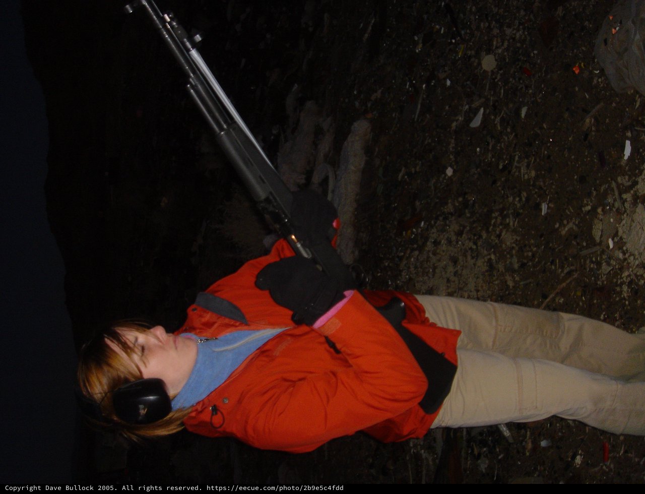 Young Woman Shooting Rifle at Night Range