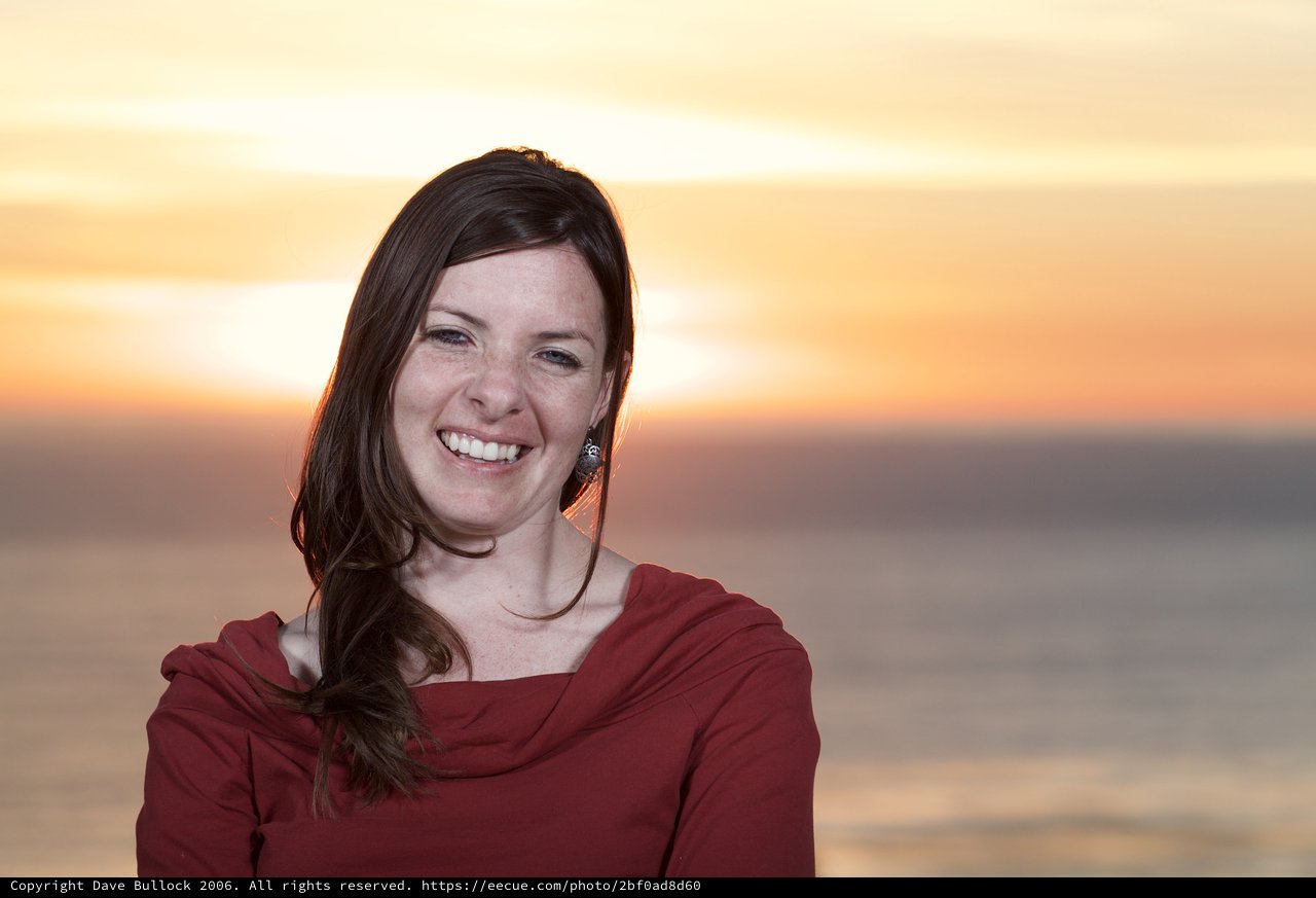 Radiant Woman Smiling at Sunset by the Sea