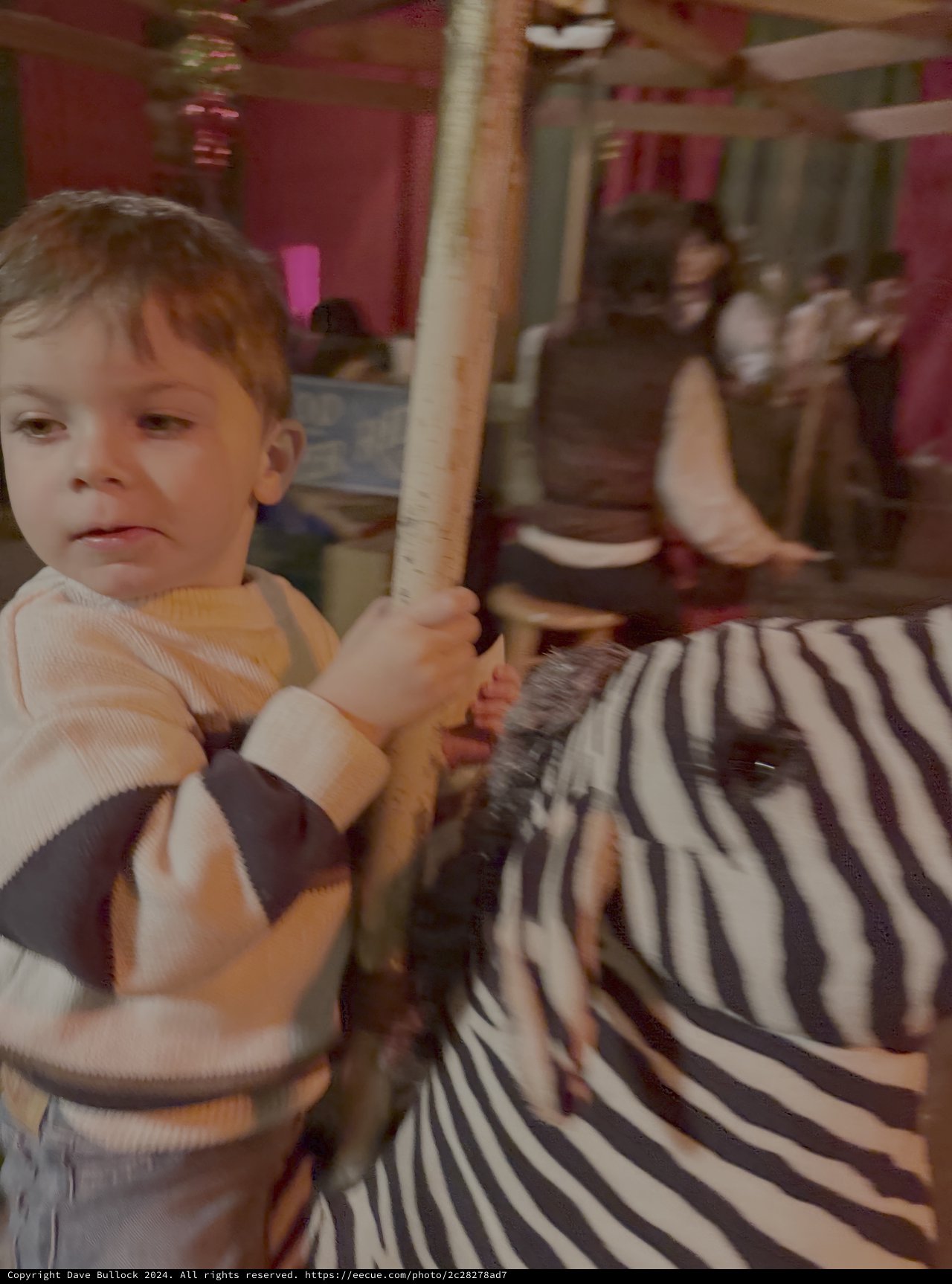 Child Riding Carousel at Indoor Amusement Park