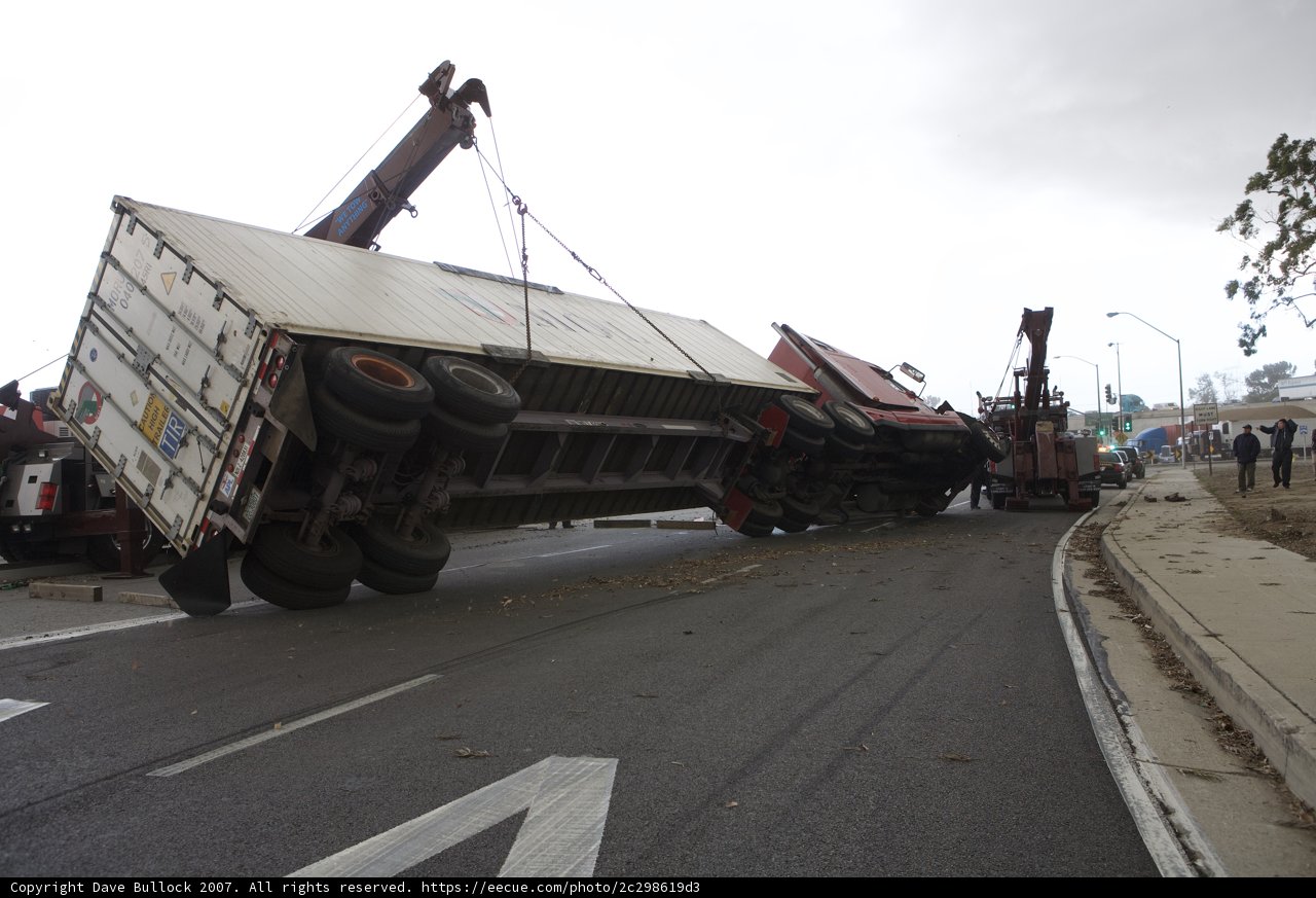 Overturned truck blocks path on busy road