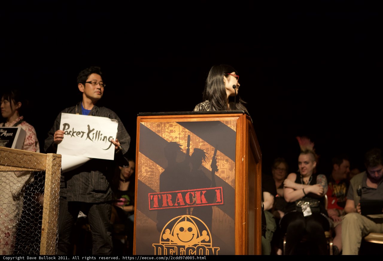 Woman delivers passionate speech to a captivated crowd Caption: Kim Yun-seok takes the podium and holds up a sign, captivating the attention of the audience gathered around her, wearing their finest accessories and listening intently to her words.