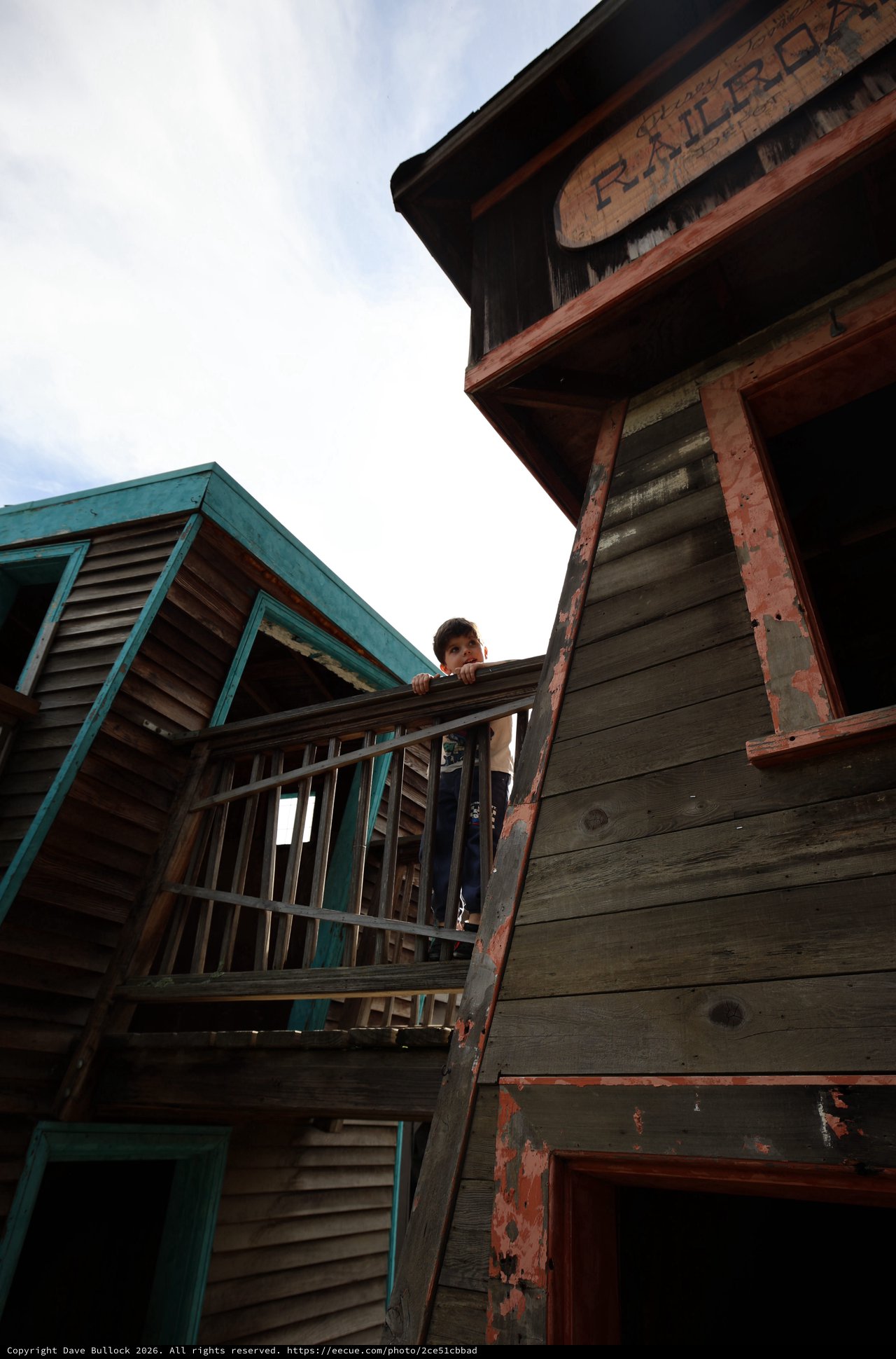 Person on Weathered Balcony of Old Western Building