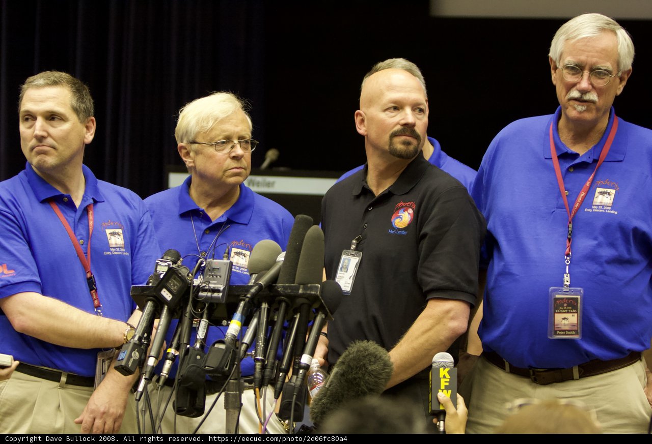 Press Conference with Four Men in Blue Shirts